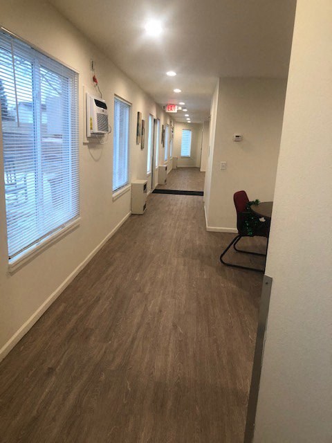 a long hallway with a chair and a window