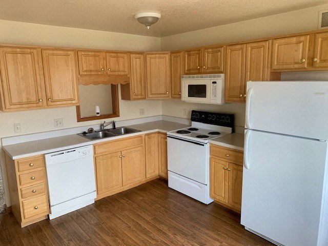 a kitchen with white appliances and wooden cabinets