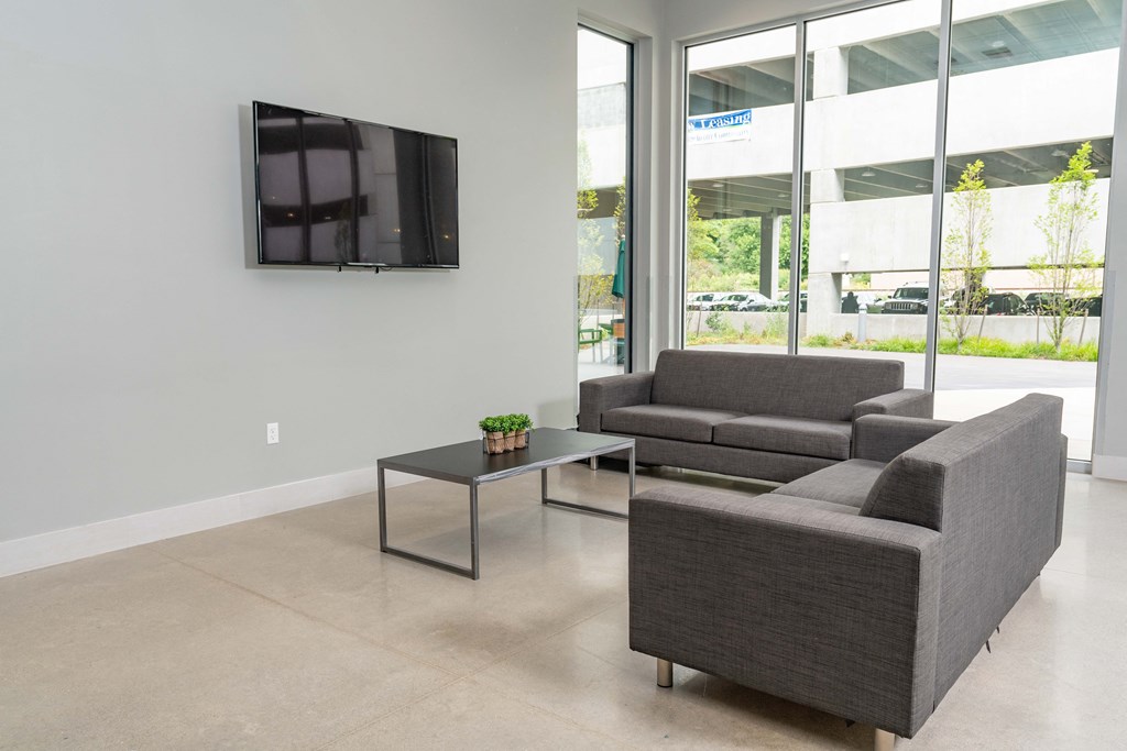 a living room with couches and a coffee table in front of a flat screen tv