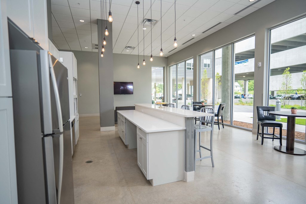 a kitchen with a long counter and a tv on the wall