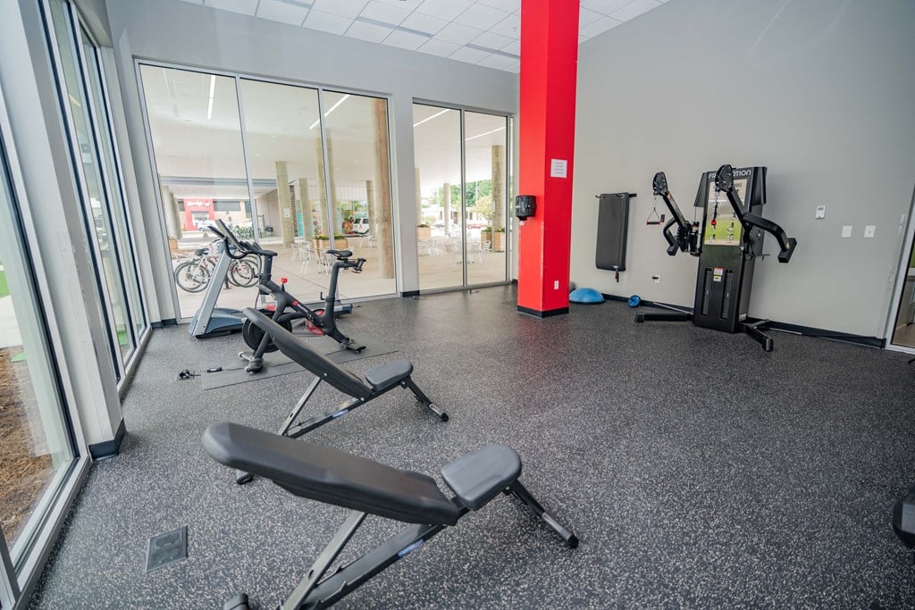 a gym with exercise equipment and a bike in the corner of a room