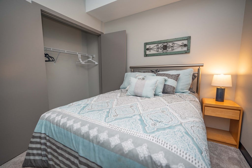 a bedroom with a bed and a nightstand with a lamp