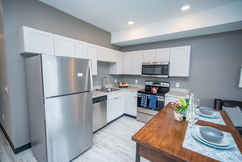 a kitchen with white cabinets and stainless steel appliances