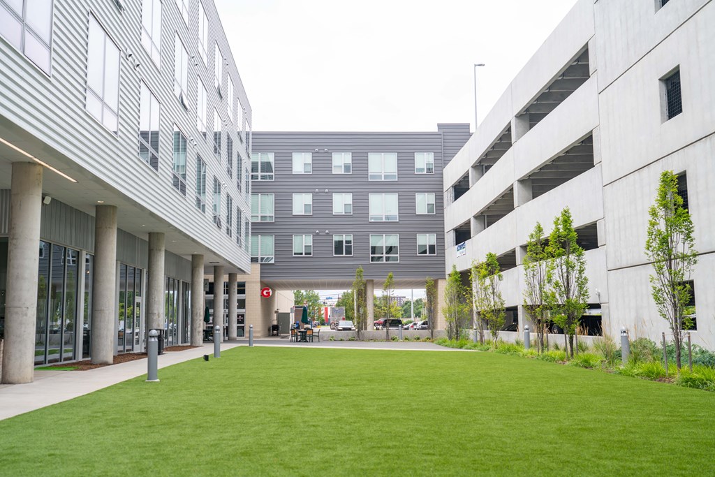 a courtyard between two buildings with a grassy area in the middle