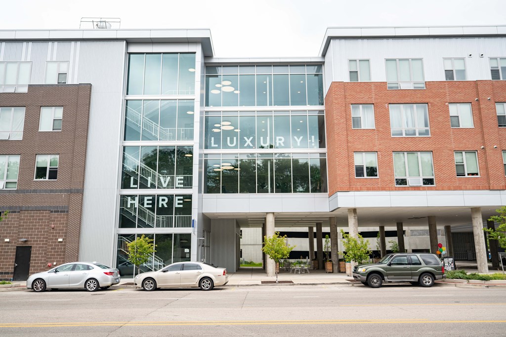 a view of the front of the luxuria building with cars parked in front of it