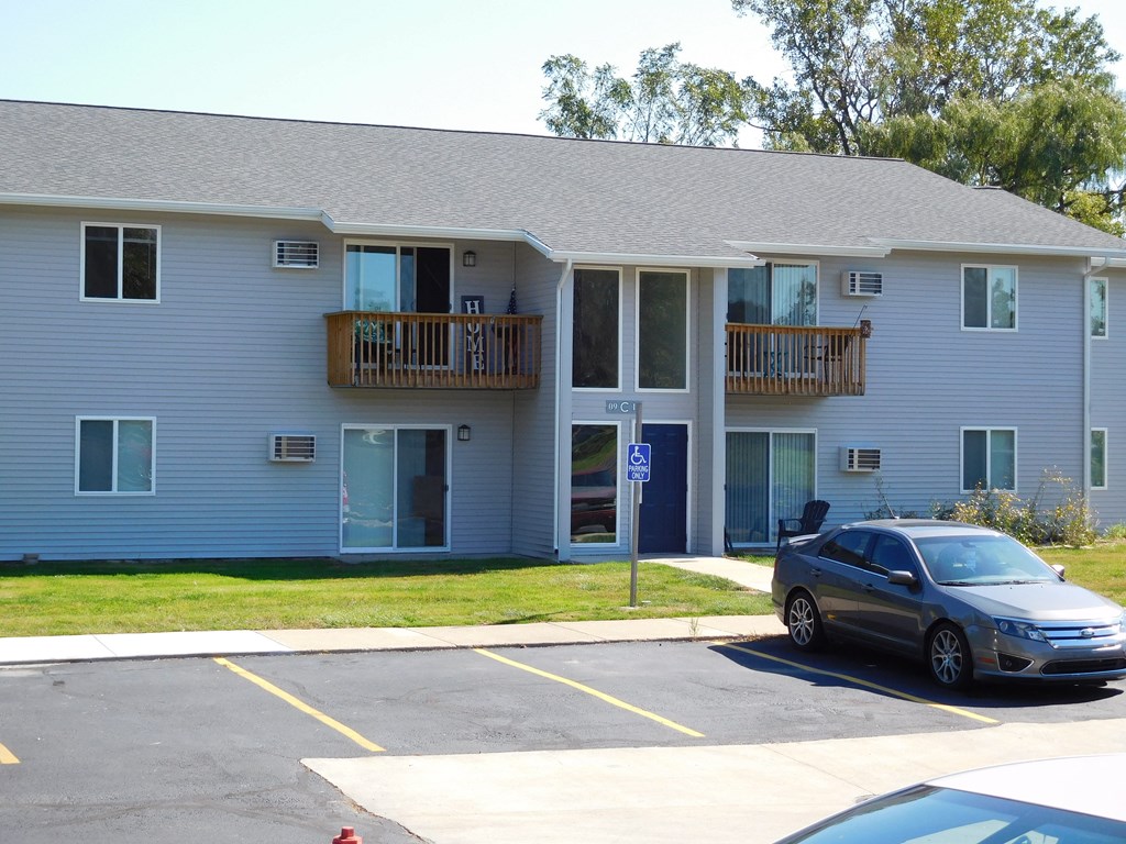 an apartment building with a car parked in a parking lot