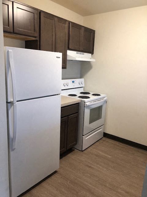 a kitchen with a white refrigerator and a stove