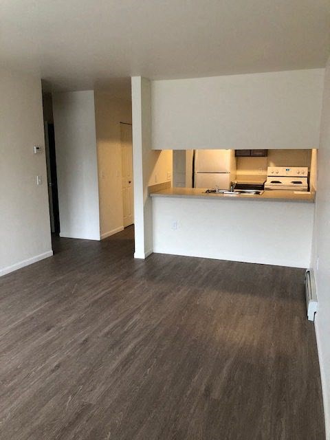 an empty living room with a kitchen in it