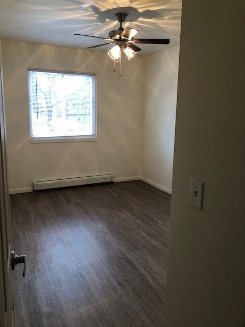 an empty room with a ceiling fan and a window