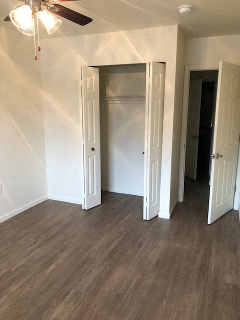 an empty room with three doors and a ceiling fan