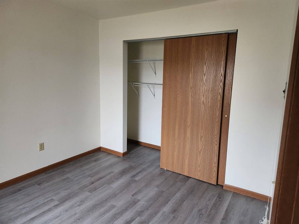 an empty room with a wardrobe and a door to a closet