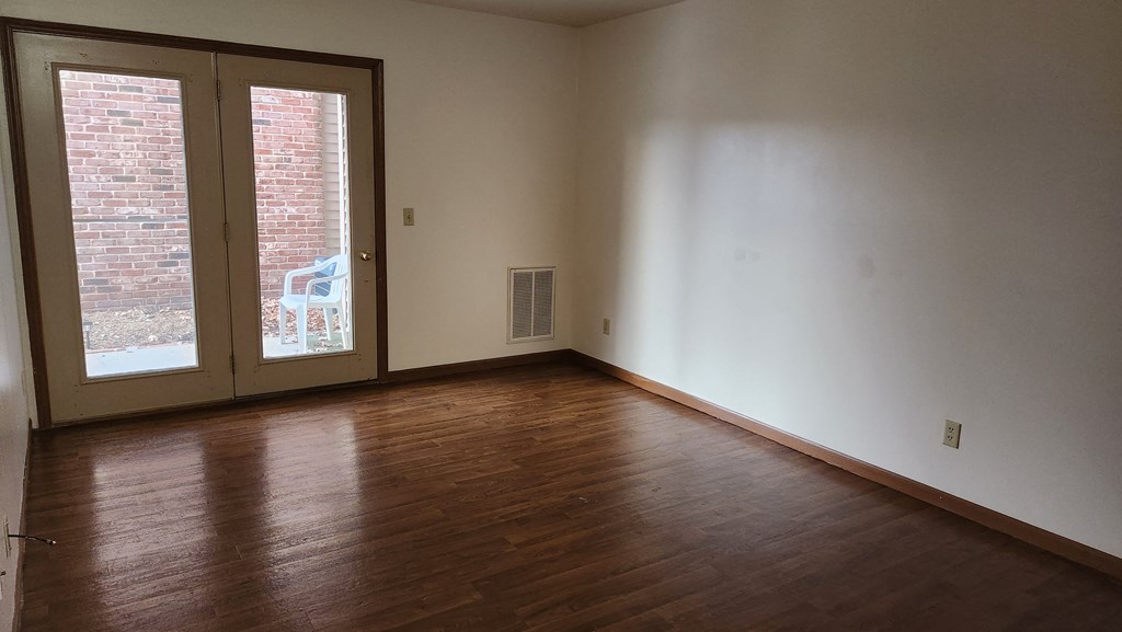 an empty living room with a door to a patio
