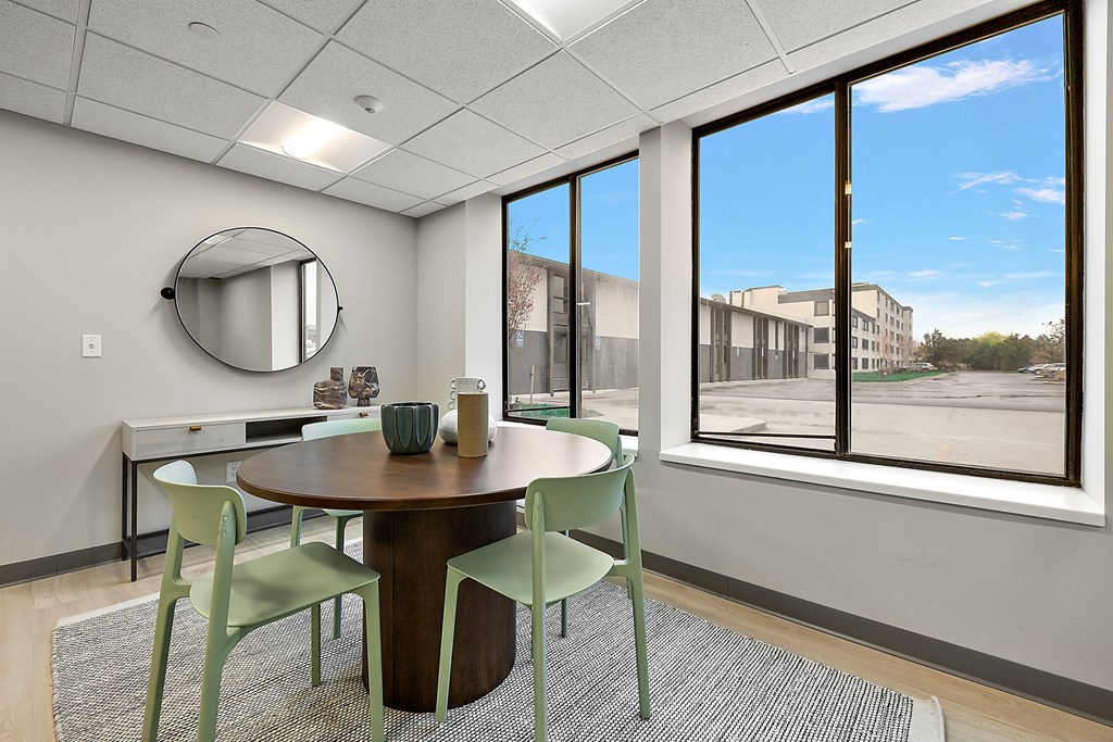 a dining area with a table and chairs and a large window