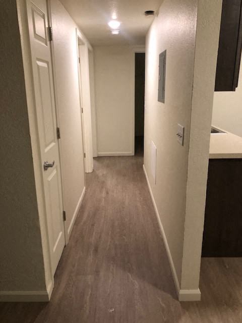 a hallway with a white door and a kitchen