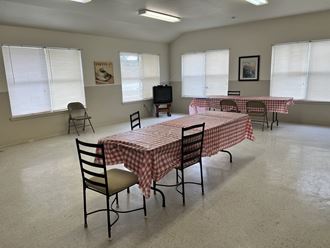 a room with a table with a checkered table cloth and a television in the corner