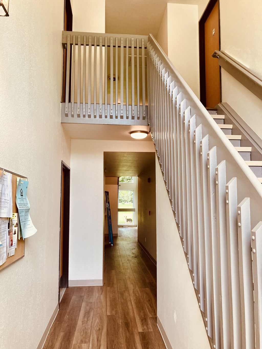 a staircase in a home with wood floors and a white railing