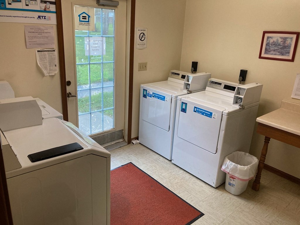 a laundry room with two washers and two dryers