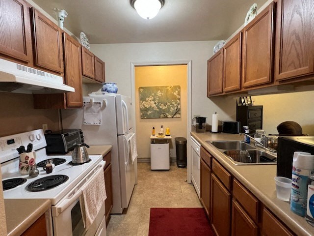 a kitchen with a white refrigerator freezer next to a stove top oven