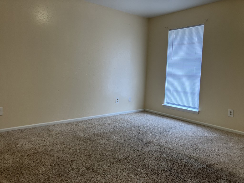 an empty room with carpet and a window