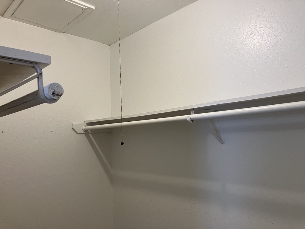 an empty closet with a pipe hanging from the wall