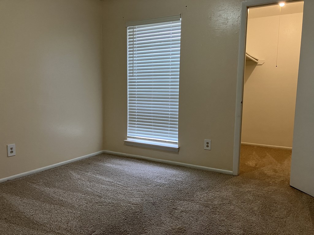 a living room with a window and a door to a closet