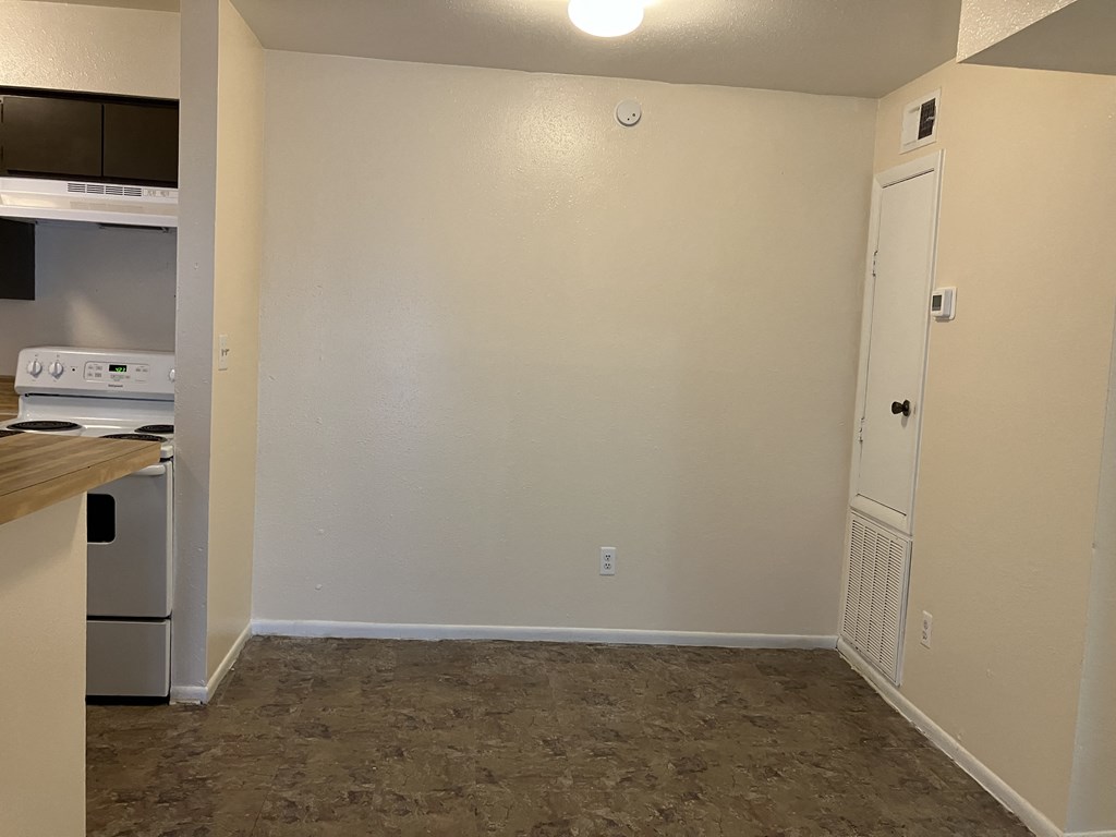an empty kitchen with a stove and a refrigerator