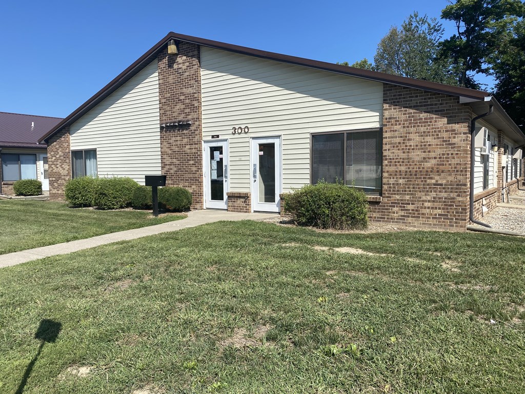 the front of a white house with a yard and grass