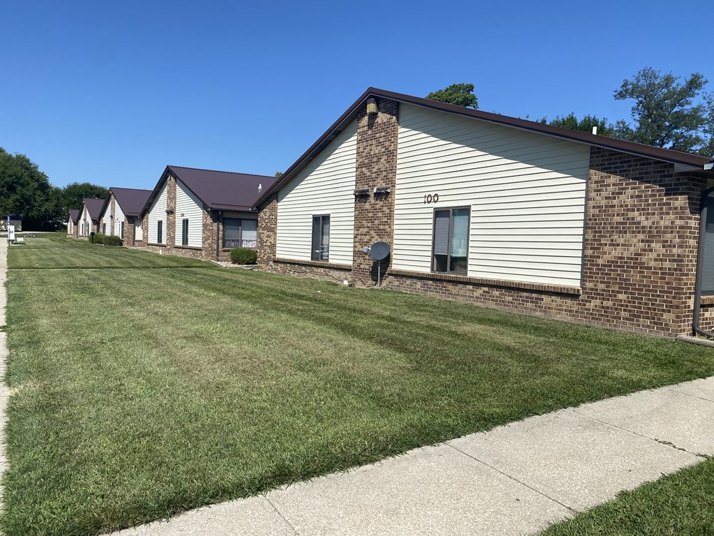 a row of houses with a lawn and a sidewalk
