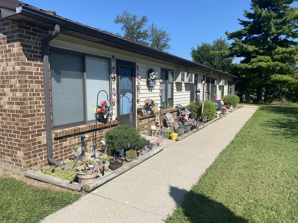 a house with a bunch of potted plants in front of it