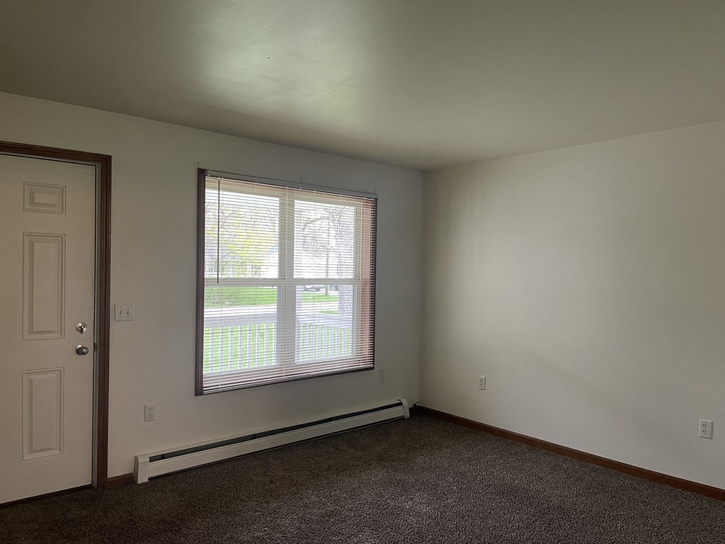 an empty room with a large window and a door