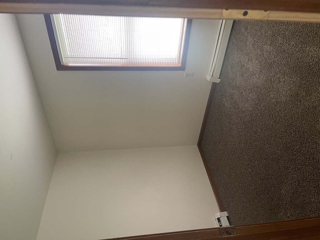 a small room with a skylight and a wooden floor