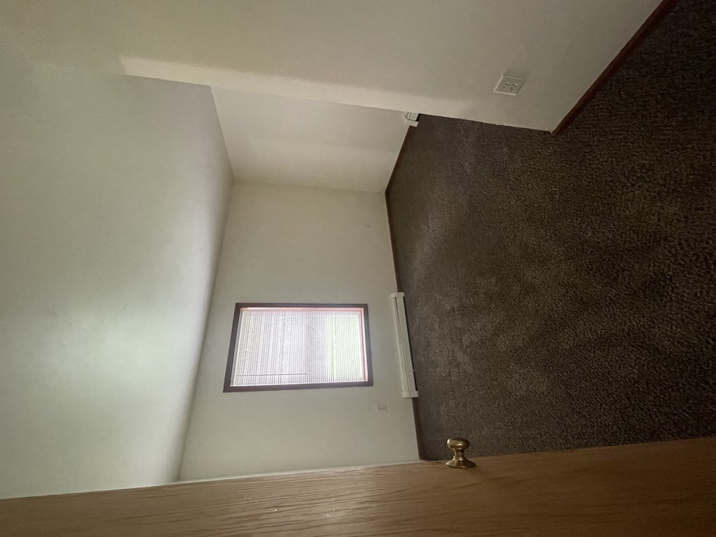 a small window in a room with a wooden floor