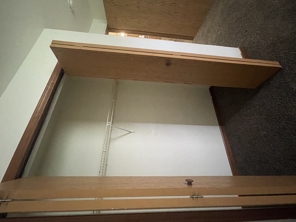 a wardrobe with an open door and a shelf above it