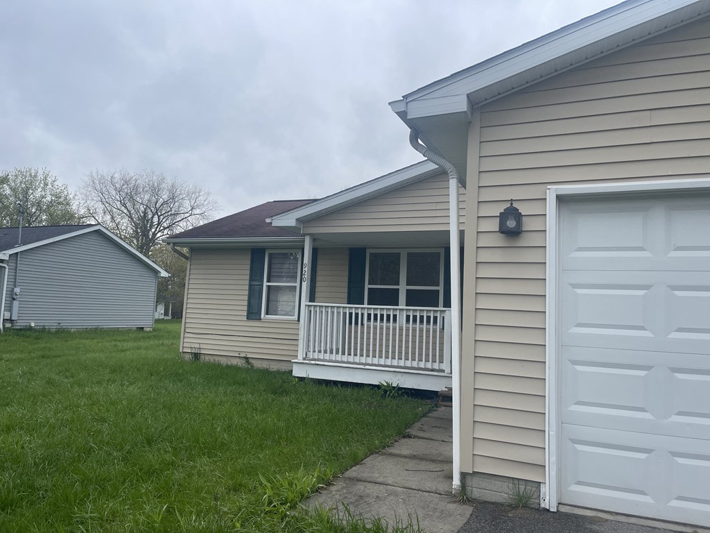 a home with a white porch and a white garage door