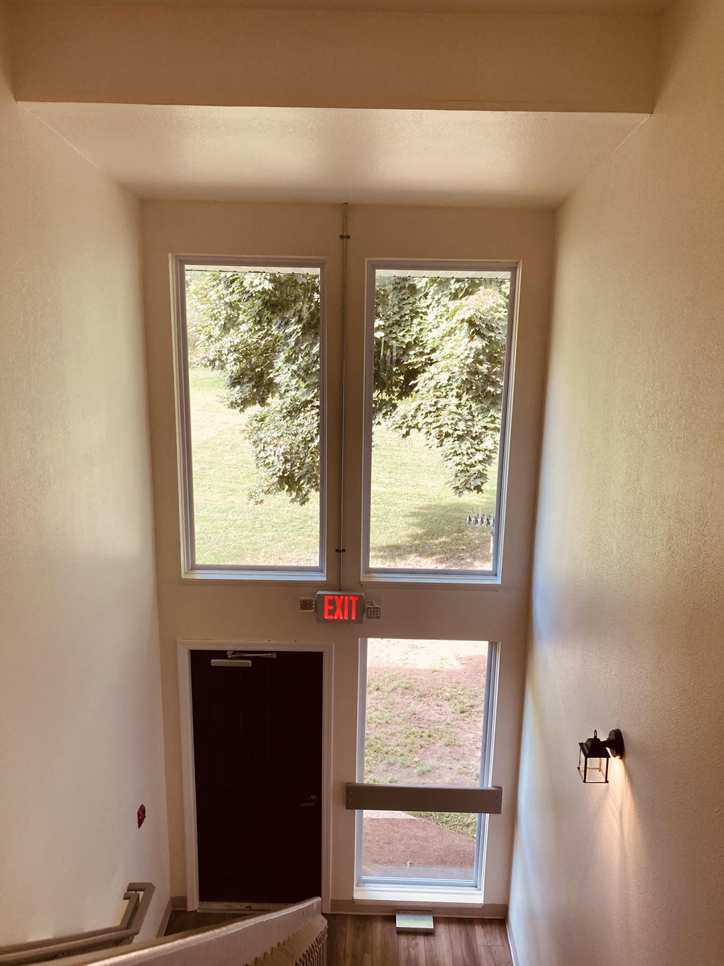 the view from the top of the stairs looking into the front door and two windows