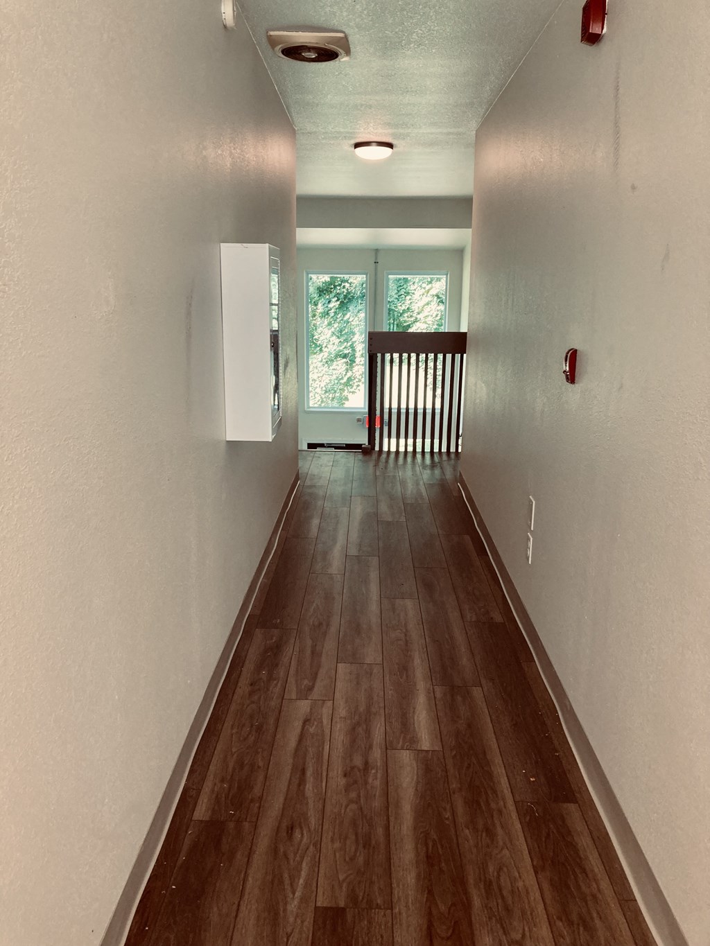 a view down the hallway of a house with wood floors