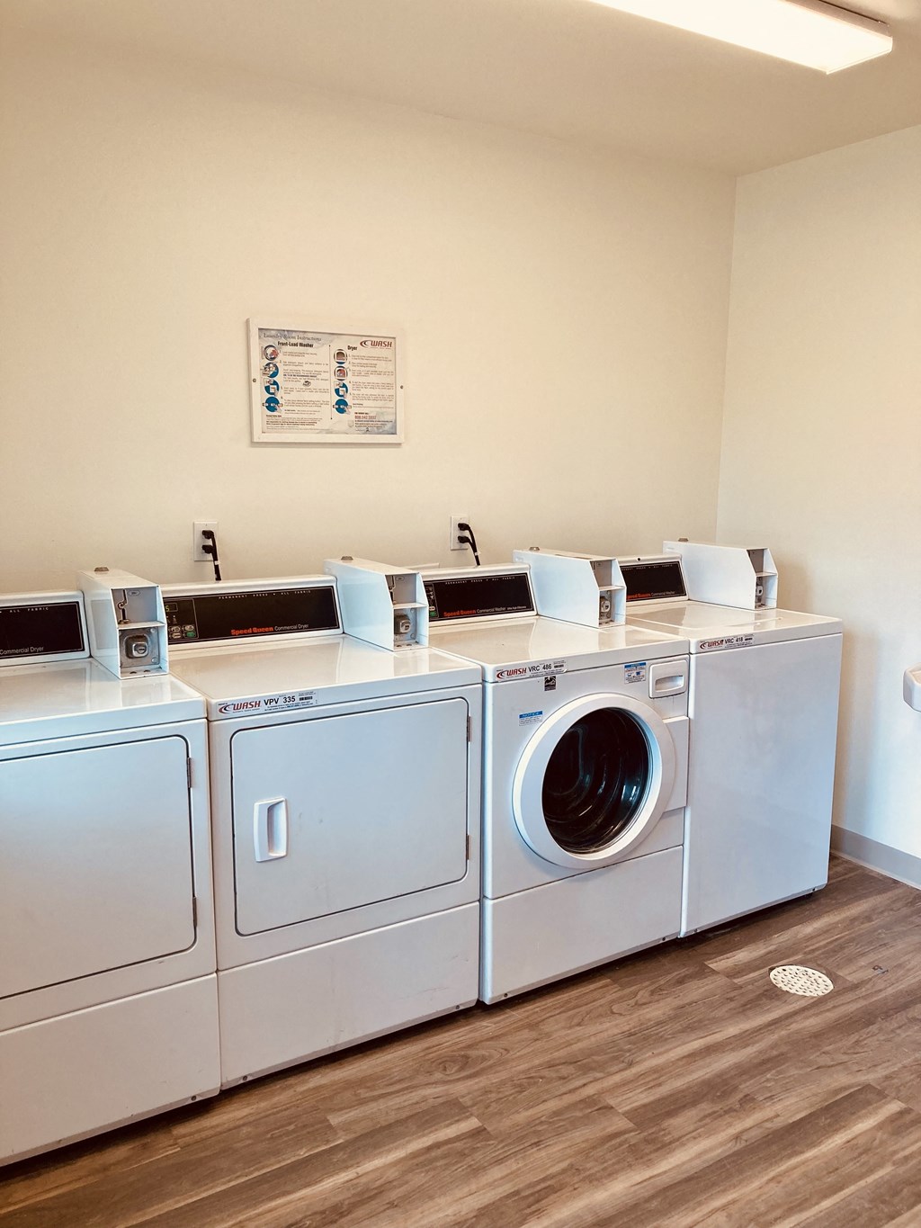 a row of washers and dryers in a laundry room