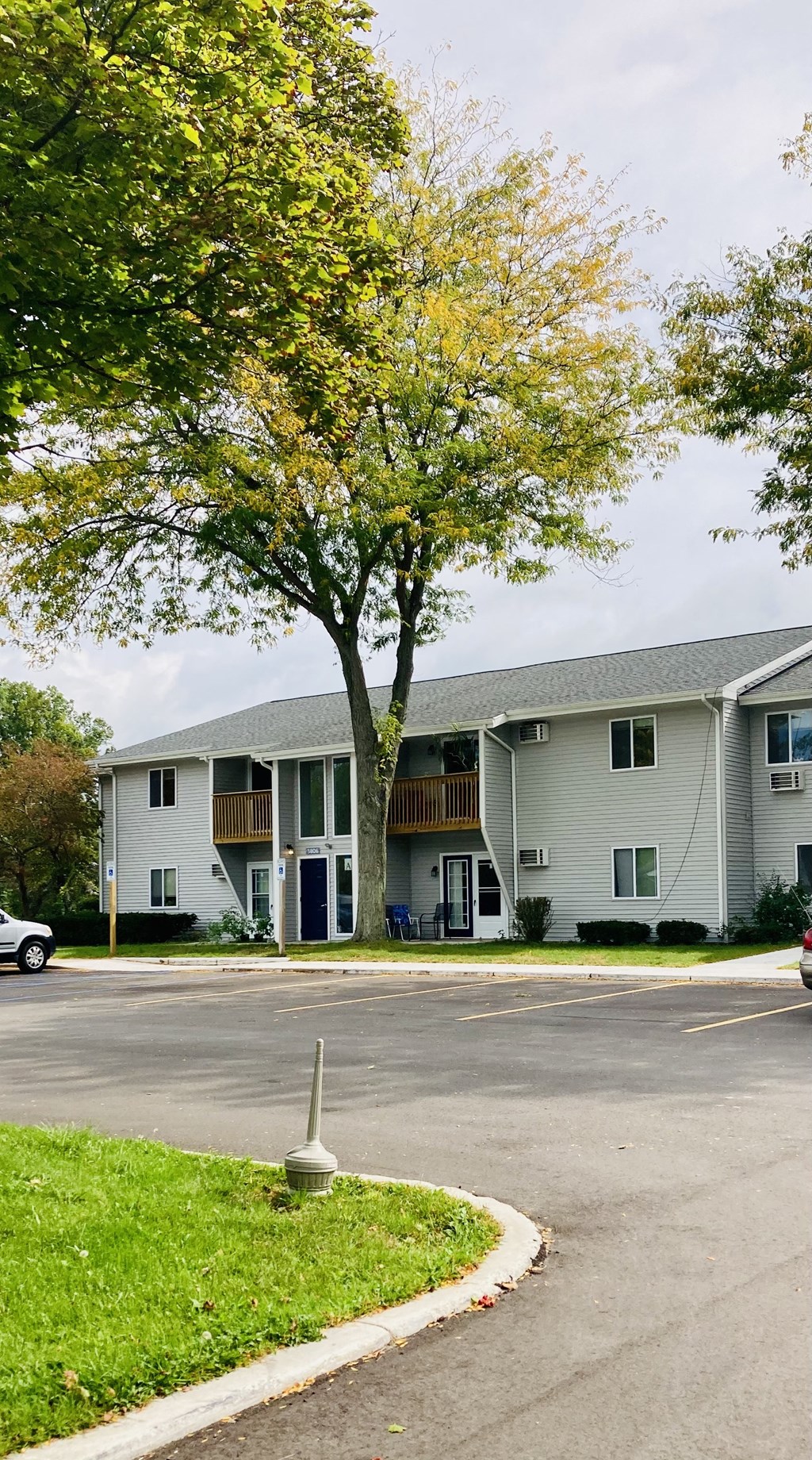 an apartment building with a tree in front of it