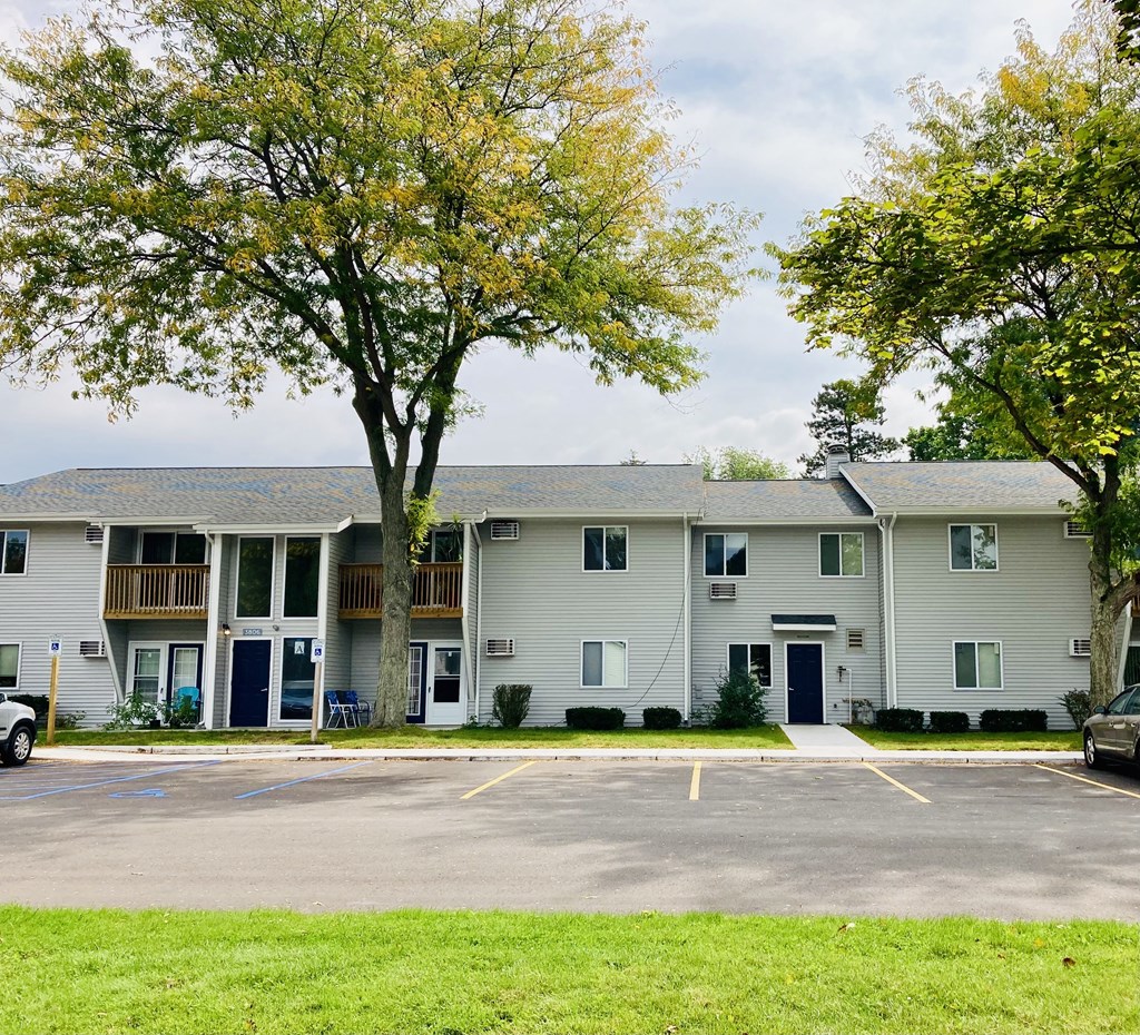 the view of an apartment building with a parking lot
