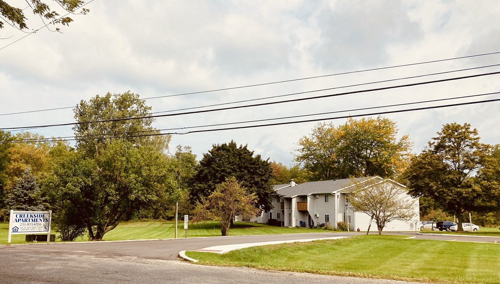 a white house on the corner of a street with power lines