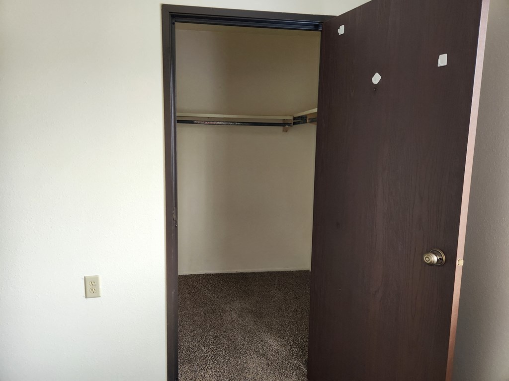 an empty closet in a room with a door open