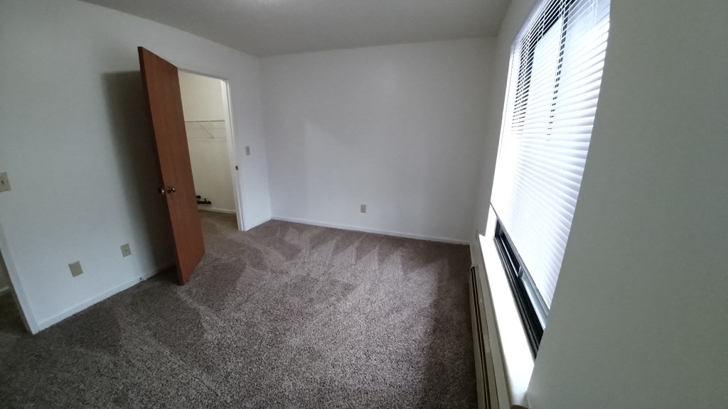 an empty room with a large window and a door