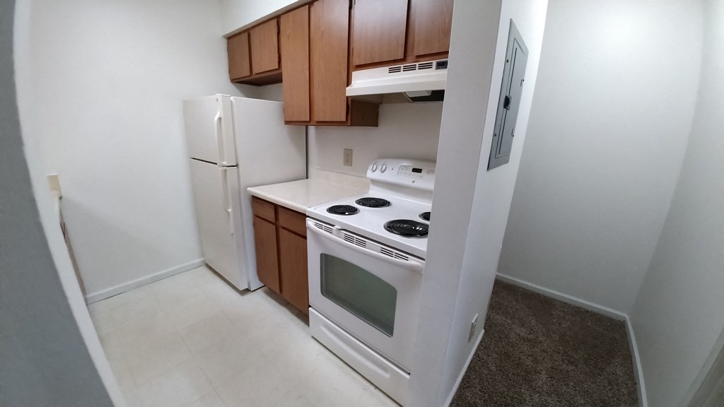 a kitchen with white appliances and brown cabinets