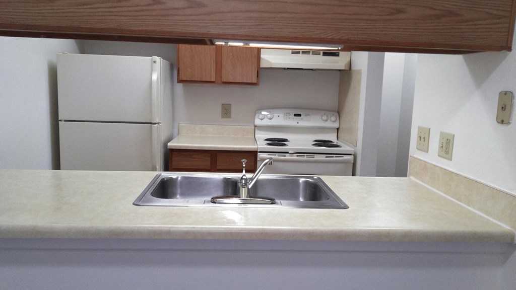 a kitchen with a sink stove refrigerator and microwave
