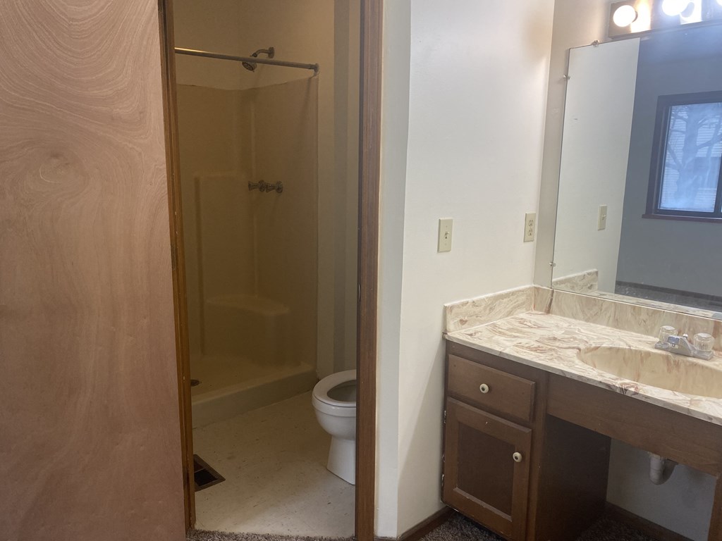 a bathroom with a toilet sink and shower