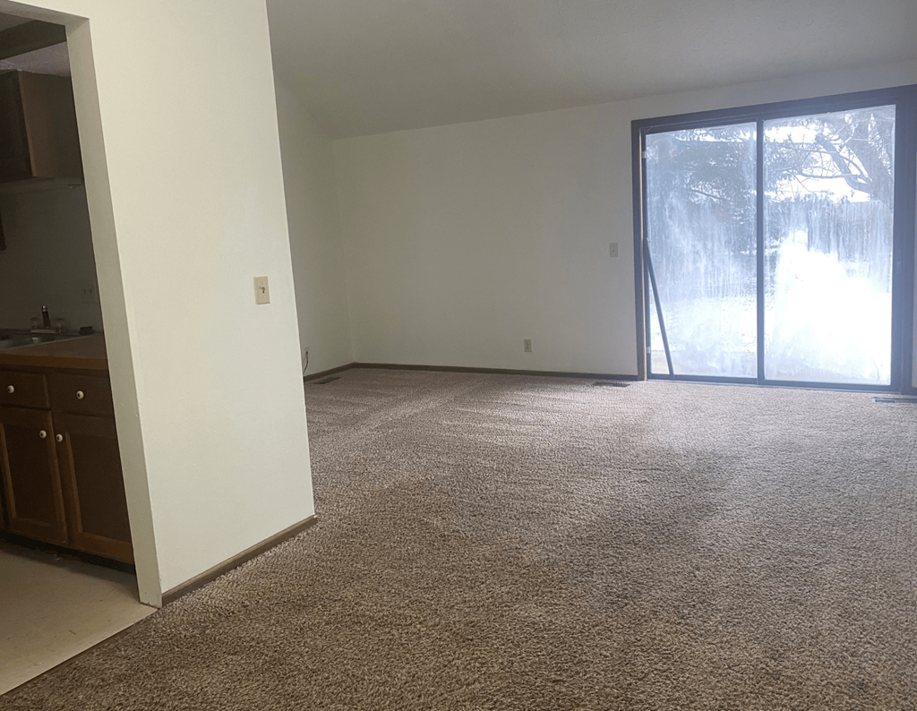an empty living room with a sliding glass door