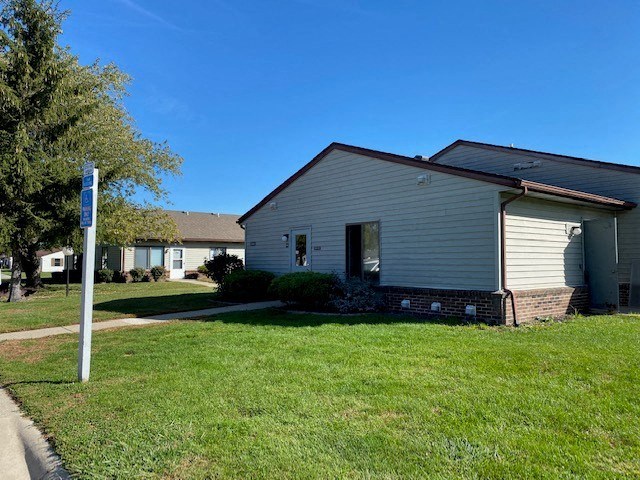 a white house with a yard and a street sign