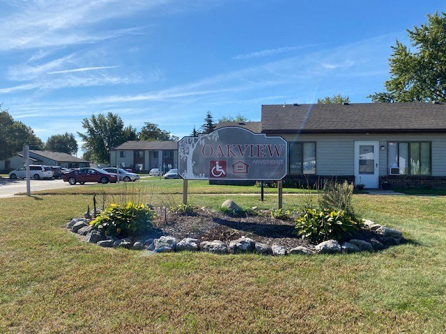 a sign in the middle of a yard in front of a building