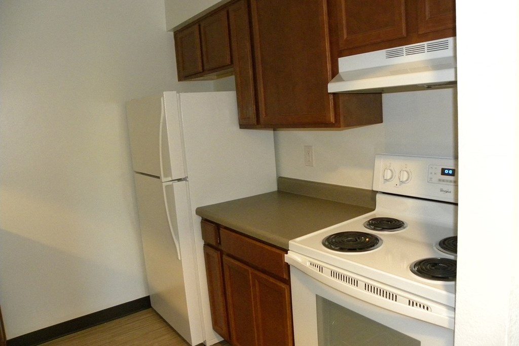 a kitchen with white appliances and wooden cabinets and a white refrigerator