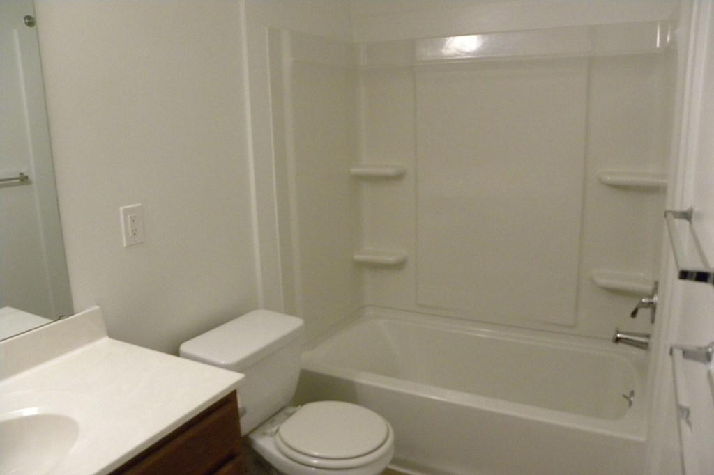 a bathroom with a toilet and a tub and a sink